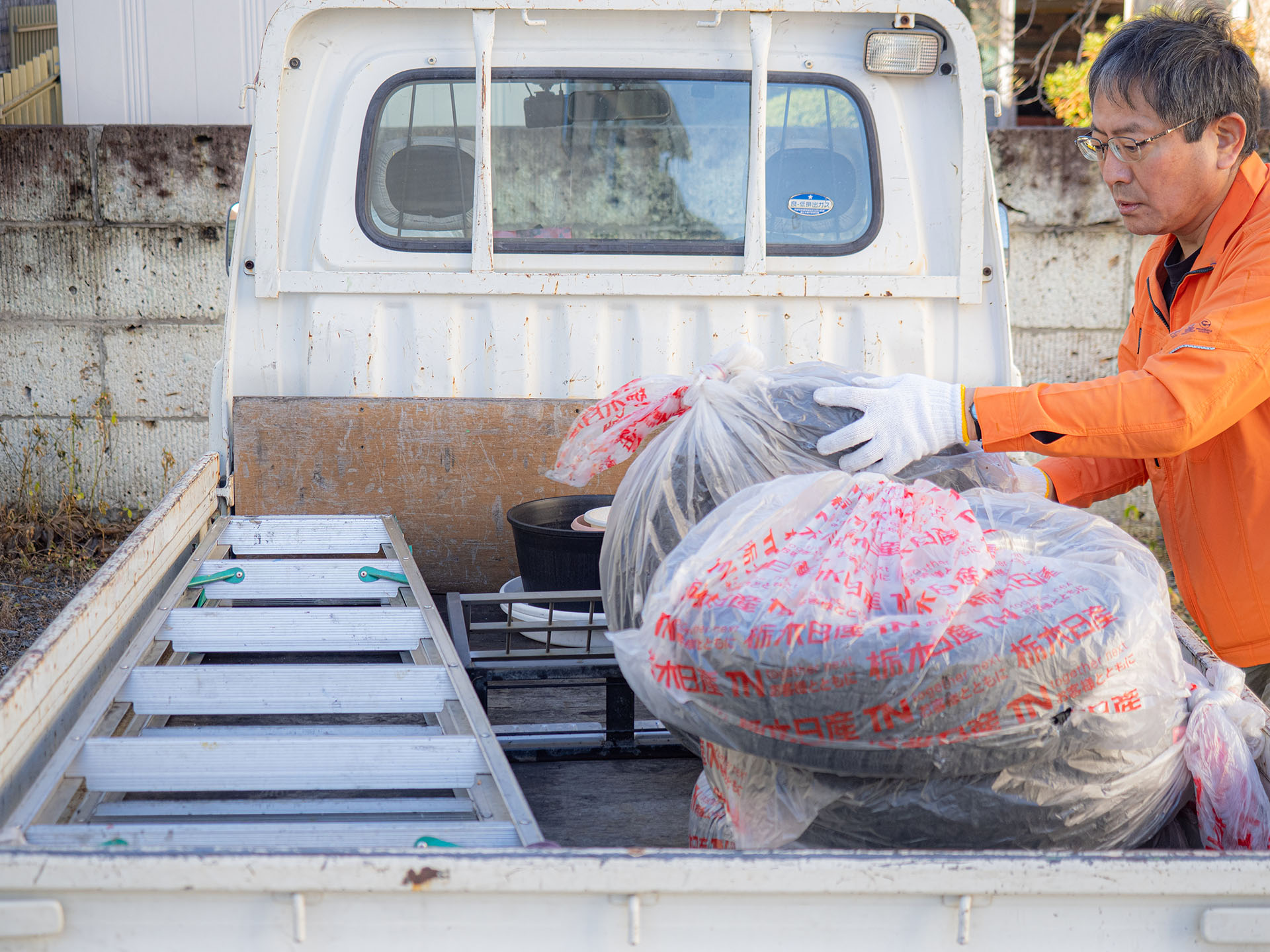 不用品を軽トラに積んでいる写真